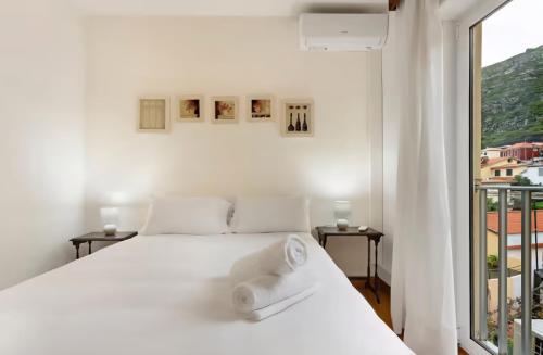 een witte slaapkamer met een bed en een raam bij Machico Bay in Machico