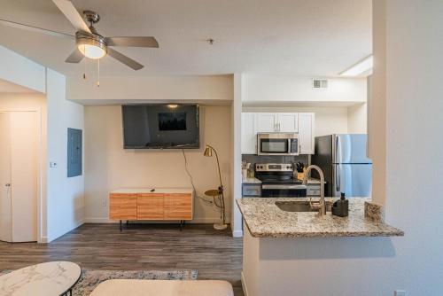 a living room with a kitchen with a counter top at Stylish Studio-1BR 1BA, Pool, Gym, Free Parking, Game Room, EV in Tempe