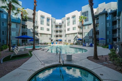 a swimming pool in an apartment complex with palm trees at Stylish Studio-1BR 1BA, Pool, Gym, Free Parking, Game Room, EV in Tempe