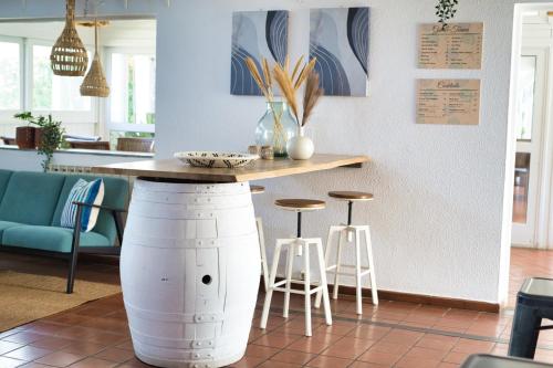 a kitchen with a counter with stools and a table at Dune Pearl Villa - Private Spa - Duna Parque Group in Vila Nova de Milfontes