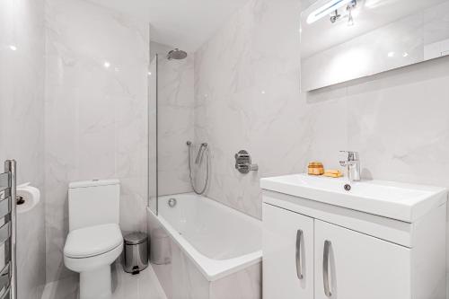 a white bathroom with a toilet and a sink at Chancery Lane Residences in London