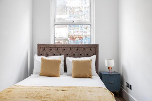 a bedroom with a bed with white walls and a window at Chancery Lane Residences in London