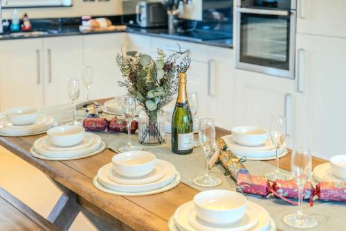 una mesa con platos y copas y una botella de vino en Rowans Stow-on-the-Wold 4 Bed Cotswolds Home, en Stow on the Wold