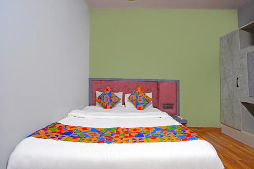 a bedroom with a large bed with colorful pillows at Via Arya in Kharadi