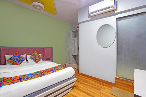a bedroom with a large bed with colorful pillows at Via Arya in Kharadi