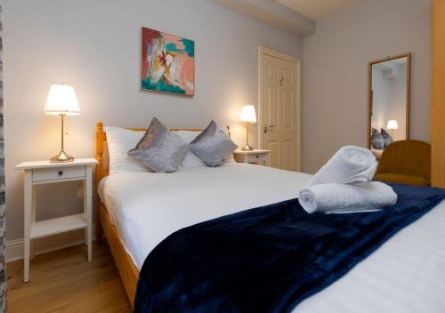 Un dormitorio con una gran cama blanca y una silla. en Tonn Na Mara - Galway Lakeside Apartments, en Galway