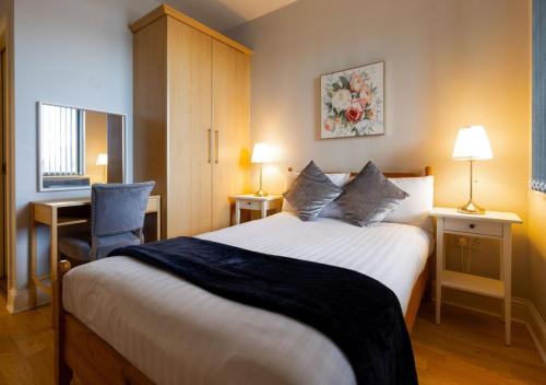 a bedroom with a bed and a desk and a chair at Tonn Na Mara - Galway Lakeside Apartments in Galway