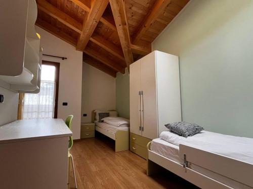 a room with two beds and a counter in it at Cèsa Nicole e Patrick in Campitello di Fassa