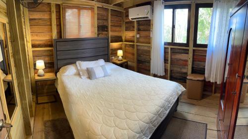 Ένα ή περισσότερα κρεβάτια σε δωμάτιο στο Negril Huts Enchantment - Cottages in trees with AC, ocean views, pool, Sea access