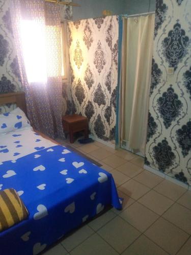 ein Schlafzimmer mit einem blauen Bett und einem Fenster in der Unterkunft Studio Ydé - Nlongkak in Jaunde