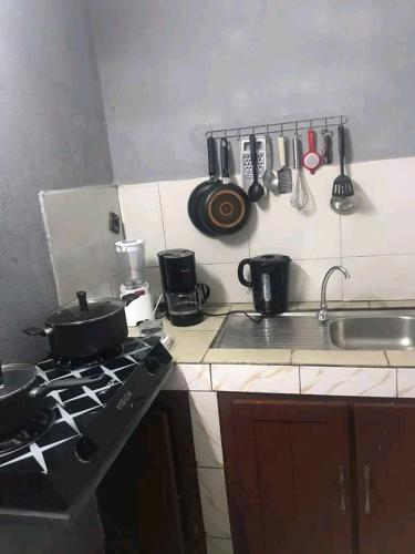 eine Küchentheke mit Töpfen und Pfannen auf einem Herd in der Unterkunft Studio Ydé - Nlongkak in Jaunde
