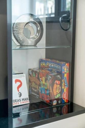 a display case with toys and games on it at Large 3BR House by D3 Short Stay, Sleeps 9, Parking & Near to Tottenham Stadium in London