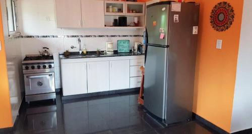 una cocina con refrigerador y estufa en Departamento villa Gesell con pileta, en Villa Gesell