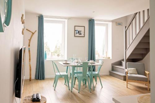 a dining room with a table and chairs and stairs at Le Presbytère des Baraques à Blériot-Plage in Sangatte