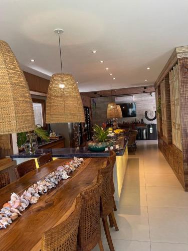 Casa nova em condominio com 4 suites spa e academia في بورتو سيغورو: غرفة طعام مع طاولة خشبية طويلة وكراسي