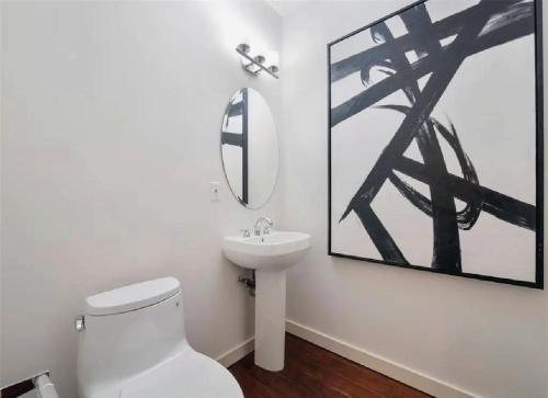 a bathroom with a white toilet and a sink at Elegant Three-Bedroom Beachfront Home With Wide Ocean Views in Redondo Beach