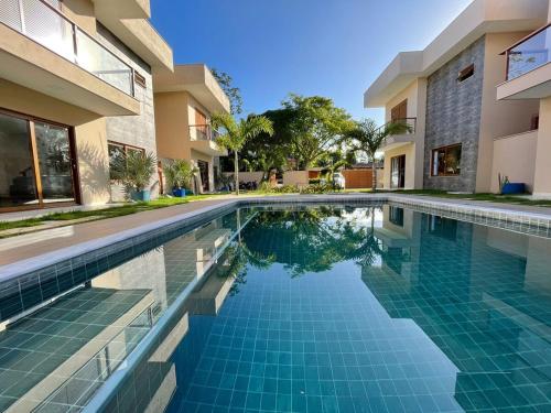 Casa nova em condominio com 4 suites spa e academia في بورتو سيغورو: حمام سباحة أمام منزل