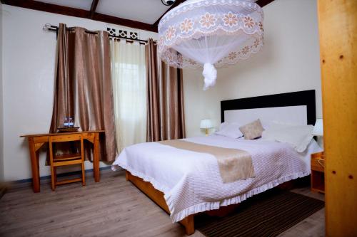 GahondoQuality Inn Motel, Nyanza的一间带床和吊灯的卧室