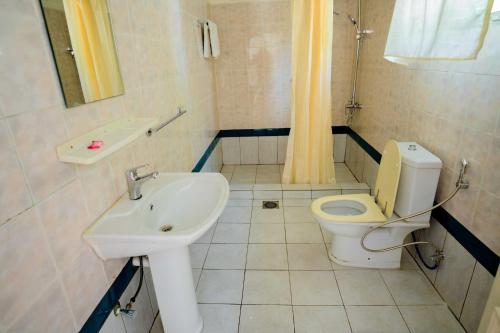 GahondoQuality Inn Motel, Nyanza的带马桶和水槽的浴室