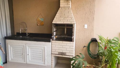 een keuken met een bakstenen oven en een wastafel bij Loft Caeté in Araruama