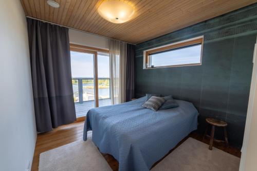 una camera da letto con un letto blu e una finestra di Villa Merellä a Kalajoki