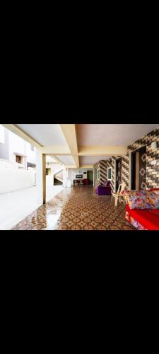 a living room with a red couch and a brick wall at Hotel RR palace iyyapanthangal near Ramachandra hospital in Chennai