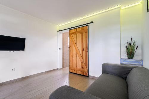 a living room with a couch and a wooden door at Casa das Pipas Palmela #6 in Pinhal Novo