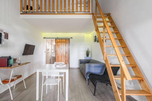 a living room with a staircase and a table and chairs at Casa das Pipas Palmela #6 in Pinhal Novo