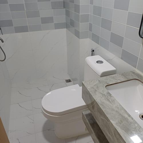 ein Badezimmer mit weißer Toilette und Waschbecken in der Unterkunft Saafu residents in Male City