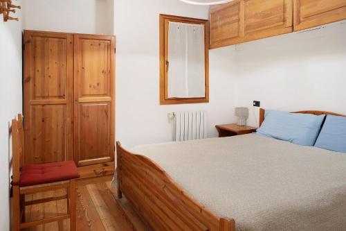 Chalet Bellavista في كييزا دي فالمالينكو: غرفة نوم بسرير كبير ودواليب خشبية