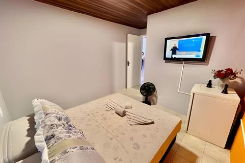 a bedroom with a bed and a tv on a wall at #MaReSiaSdaPaz próximo ao centro de Matinhos in Matinhos