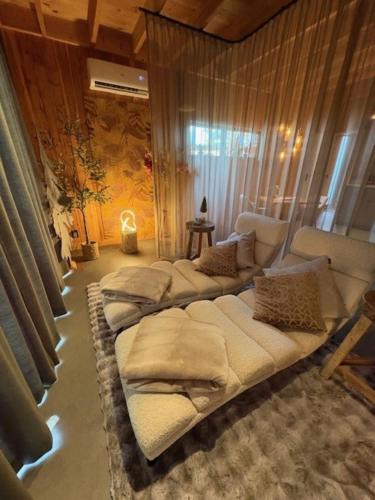 a room with three beds in a room with curtains at Wellnesslodge Kievit jacuzzi sauna and privacy in Dalerveen