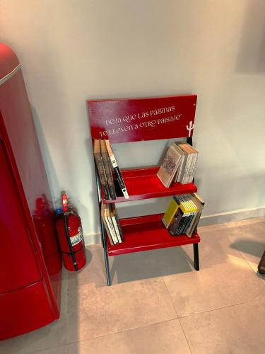 a red chair with a stack of books on it at Terra Alta Suites in Salta