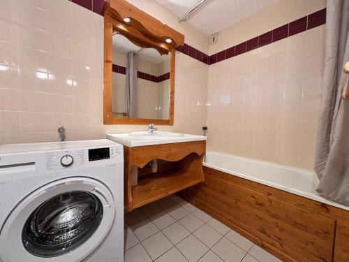 een badkamer met een wasmachine en een wastafel bij Résidence Saboia B54 Clés Blanches Courchevel in La Tania