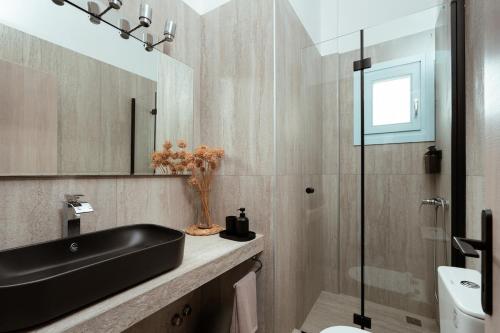 a bathroom with a black sink and a mirror at Kyma Paros Apartments 1 