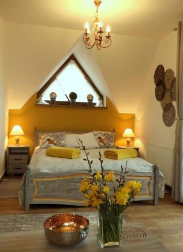 a bedroom with a bed with a window and a vase of flowers at Willa Misiowa Chata in Czarna Góra