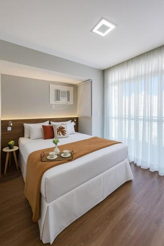 una grande camera da letto con un grande letto e una finestra di Flat Praia do Canto Collection View a Vitória