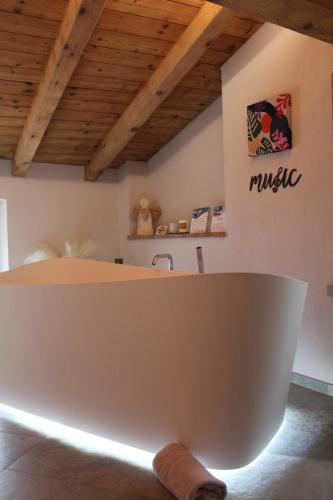 a white bath tub in a room with a wooden ceiling at Twinssuites - Adults only in Limone sul Garda