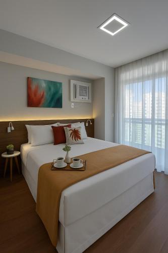 una camera da letto con un grande letto con due piatti sopra di Flat Praia do Canto Collection View a Vitória