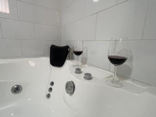 2 copas de vino encima de la bañera en Habitación doble con Jacuzzi, en Curicó