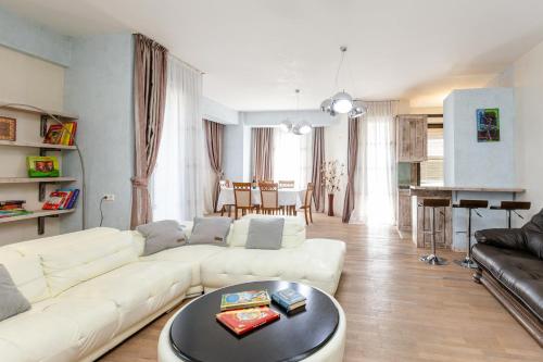 Una sala de estar con un sofá blanco y una mesa. en Cityview Elegance, en Tiflis