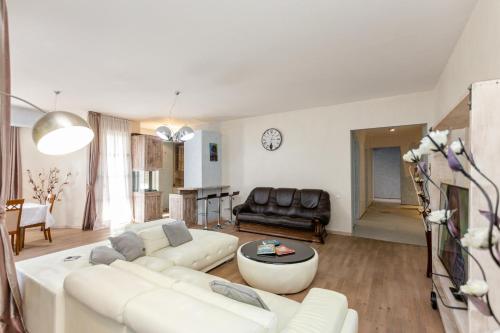 Una sala de estar con un sofá blanco y una mesa. en Cityview Elegance, en Tiflis