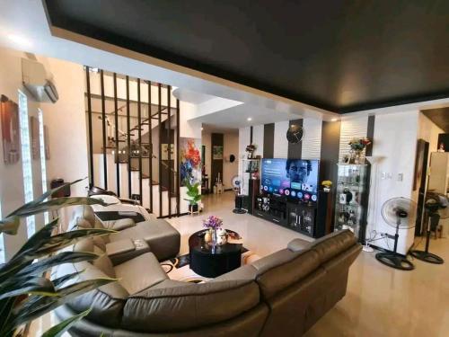 Stella Dream Escape في مانيلا: غرفة معيشة مع أريكة بنية اللون وتلفزيون