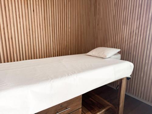 una cama en una habitación con una pared de madera en Moderno y equipado, cerca del Paseo la Galeria, en Asunción