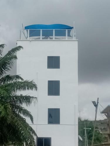 ein weißes Gebäude mit blauem Dach darüber in der Unterkunft Regal Royal Suites in Kokrobite