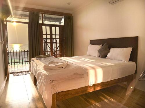 a bedroom with a large bed with a large window at Secret Garden Agonda Beach Resort in Agonda