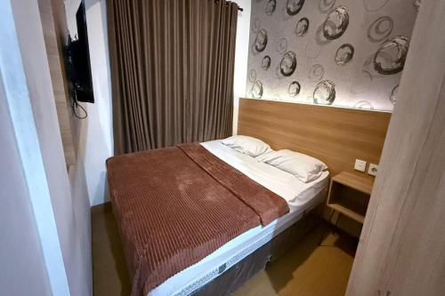 a small bedroom with a bed and a wall with plates at Senayan Suites in Jakarta