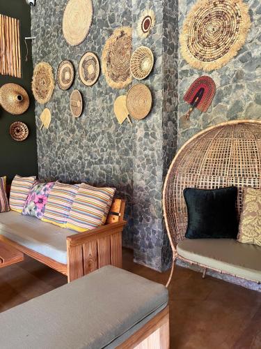a room with wicker chairs and hats on the wall at Marini Ndoto in Themi