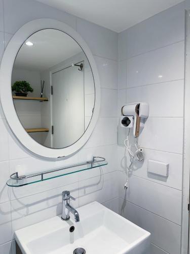 a white bathroom with a sink and a mirror at Cozy room at Hillside2 Condo in Chiang Mai