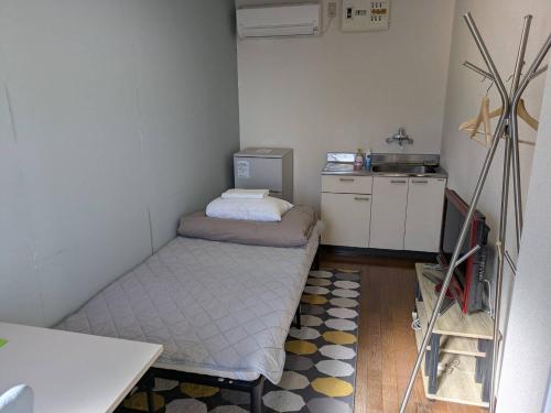 a small room with a bed and a kitchen at Guest House Tsuu Odawara ゲストハウスTSUU小田原 #OD1 in Odawara